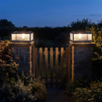 Cassia pillar lights flanking a garden gate at dusk