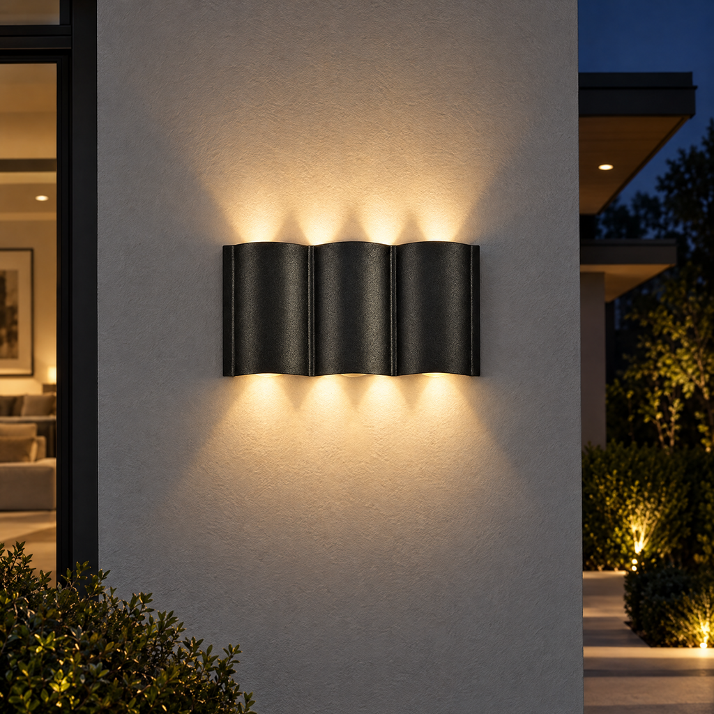 Black wave up and down outdoor wall light on gray facade at night
