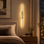 Modern linear wall sconce beside a bed in a bedroom