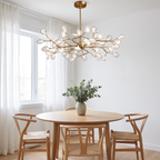 Lumi firefly LED pendant light hangs over a round oak table in a bright Scandinavian breakfast nook
