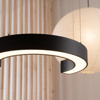 Arca C-shaped LED pendant light close-up detail lit up