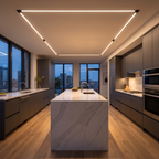 Channel recessed LED strip light lines are recessed in the ceiling of a sleek modern kitchen with handleless grey cabinets and a quartz island