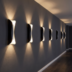 Beam up-and-down LED wall light a row of them mounted on a dark grey hallway wall