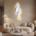 Plumage backlit feather LED wall decor light mounted on the wall above a curved sofa in a chic living room with neutral tones