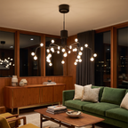 Retro adjustable branching chandelier with glass spheres hangs in a mid-century modern lounge with a teak sideboard