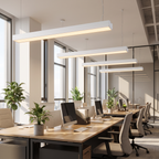 Grid commercial modular linear LED pendant light hangs over rows of desks in a bright modern open-plan office with plants and glass partitions