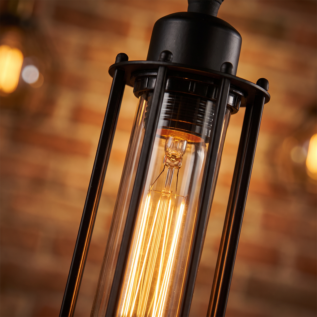 Forge industrial black iron and glass tube pendant light close-up detail lit up