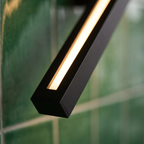 Linden long vertical black linear LED wall sconce close-up detail lit up