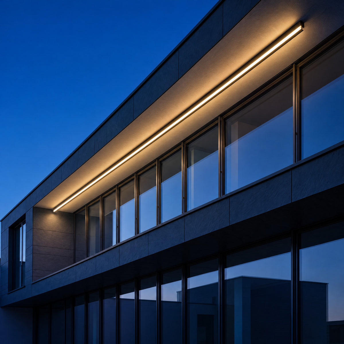 Lumea linear wall lights along a building facade at dusk