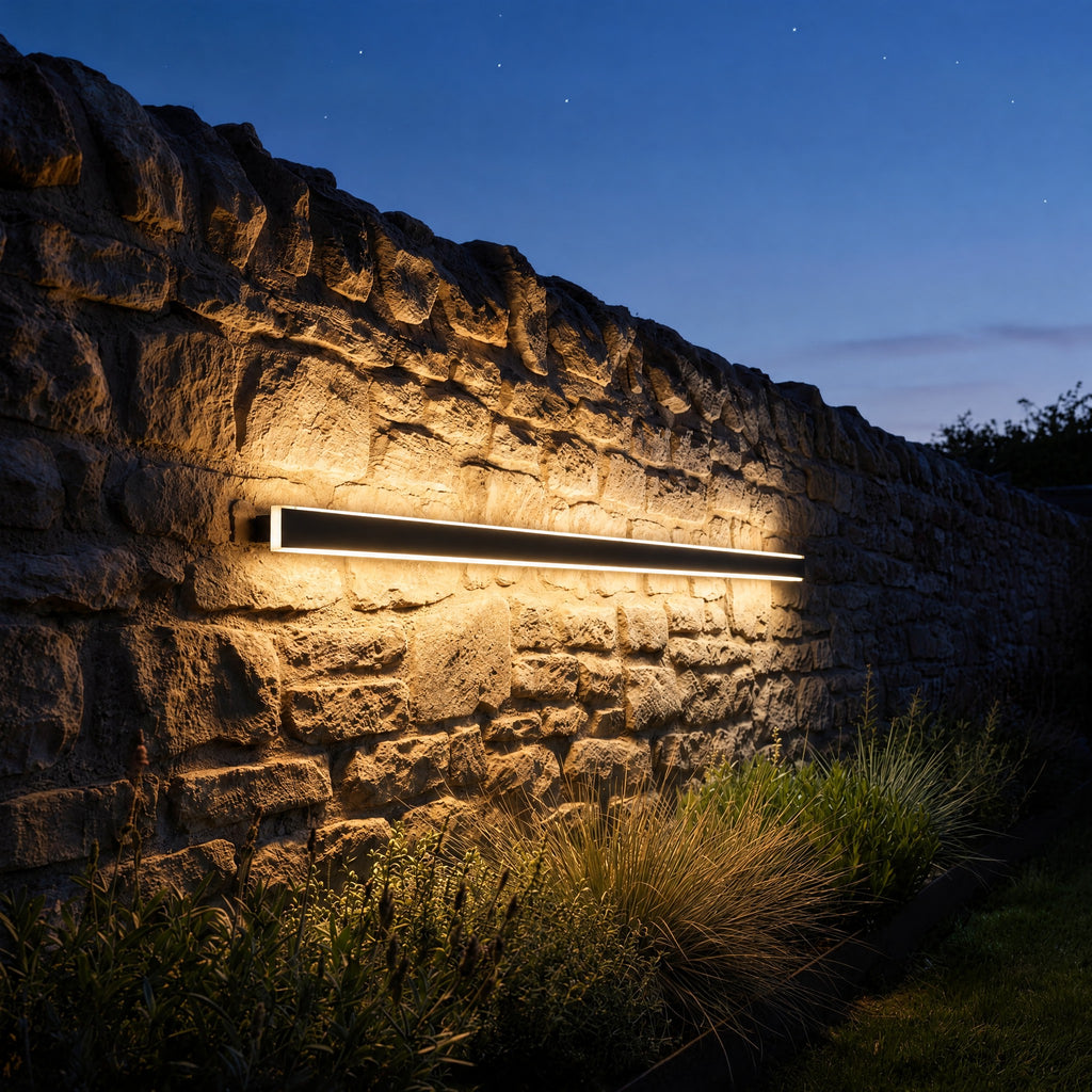 Lumea wall light on a stone garden wall at dusk