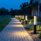 Nordal bollard lights lining a stone garden path at blue hour